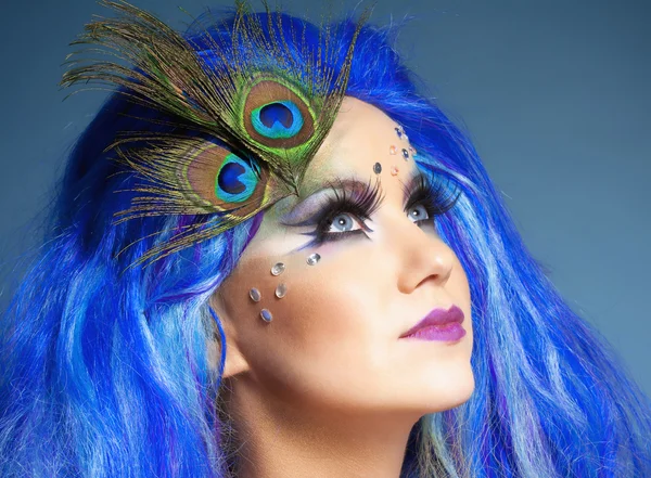 Женщина в голубом парике и павлиньих перьях — стоковое фото