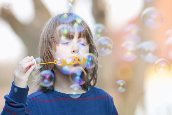 Chlapec foukat bubliny venku — Stock fotografie