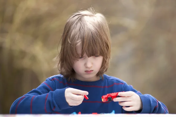 Junge baut sein Spielzeugauto zusammen — Stockfoto