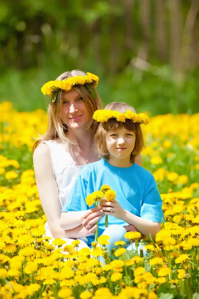 Mutter und Sohn im Löwenzahnfeld — Stockfoto