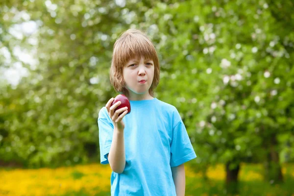 Chlapec jíst červené jablko — Stock fotografie