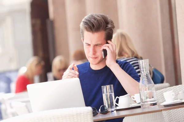 Ung Man sitter och pratar på telefon — Stockfoto