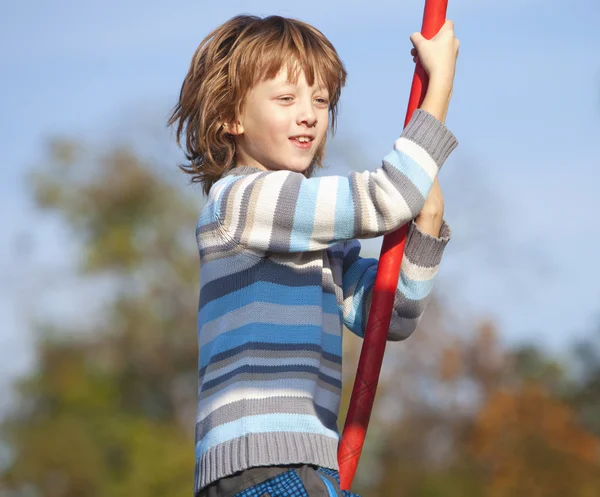 Jongen op een schommel in de speeltuin — Stockfoto