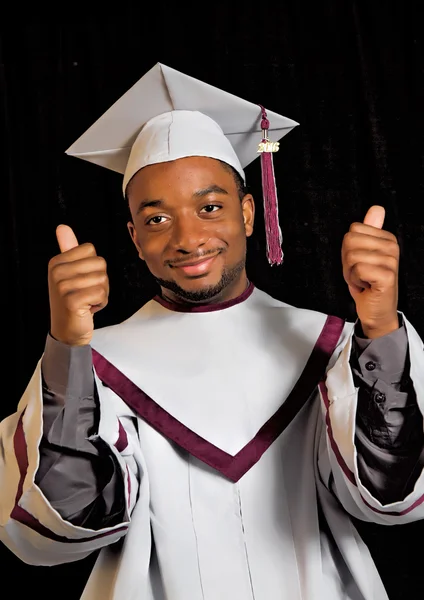 Étudiant masculin en casquette et robe de graduation - pouce levé — Photo