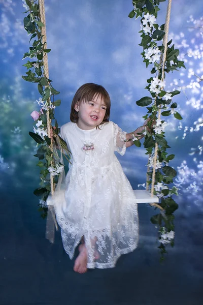 Meisje op Swing met bloemen — Stockfoto