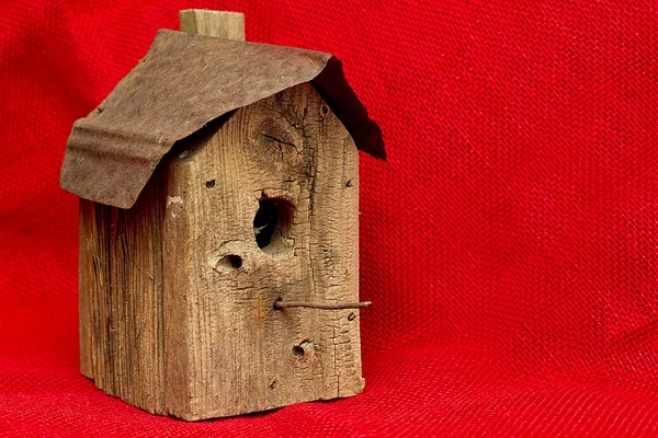 Régi kopott és viharvert Birdhouse elszigetelt piros zsákvászon — Stock Fotó