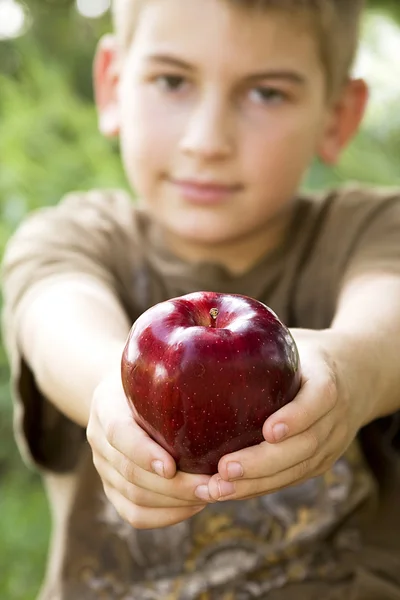 Černobílý obraz chlapce a červené jablko — Stock fotografie