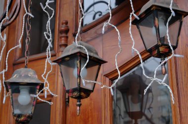 Lviv 'in merkezindeki ahşap kapının arkasındaki sokak lambaları ve çelenkler.