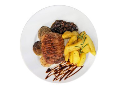 Biftek ve patates kızartması beyaz tabakta izole edilmiş.