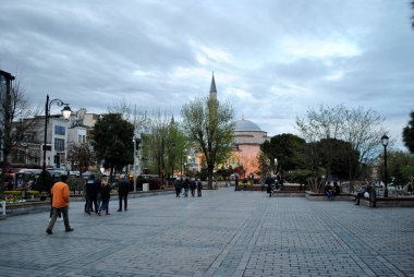 Turistler akşam caminin yakınında yürüyorlar.
