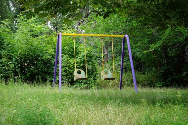 Şehirde yaşlı ve yalnız bir Sovyet salıncak sallıyor.                               