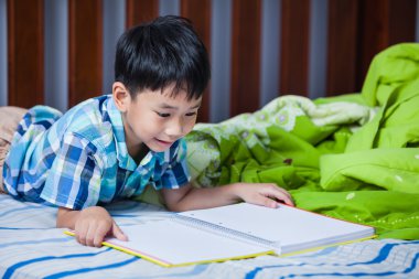 Asyalı çocuk kitap okuyorum. Eğitim kavramı.