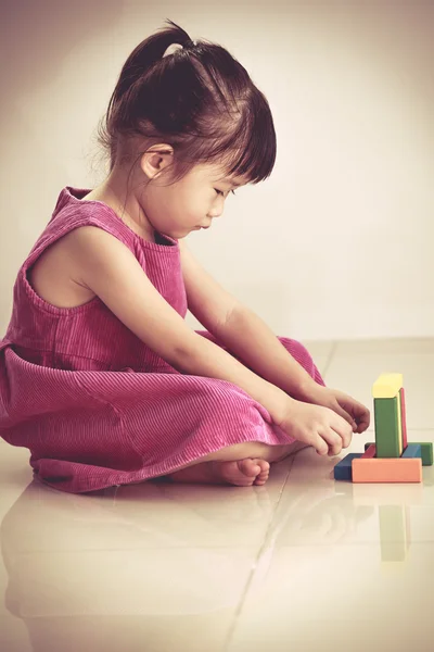 Precioso asiático chica jugando con bloques juguetes en el suelo — Foto de Stock