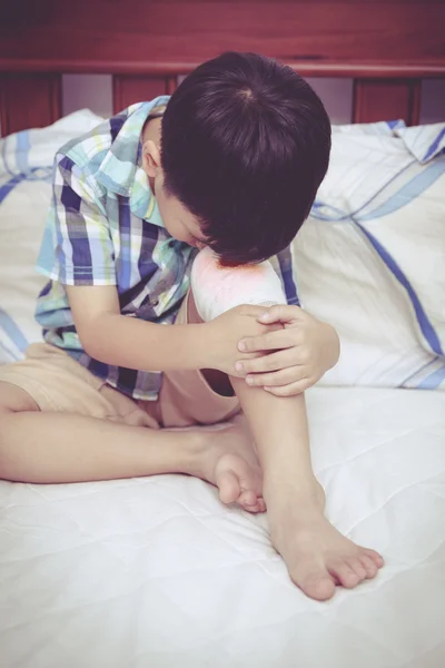 Niño herido. Herida en la rodilla del niño con vendaje. Estilo vintage . — Foto de Stock