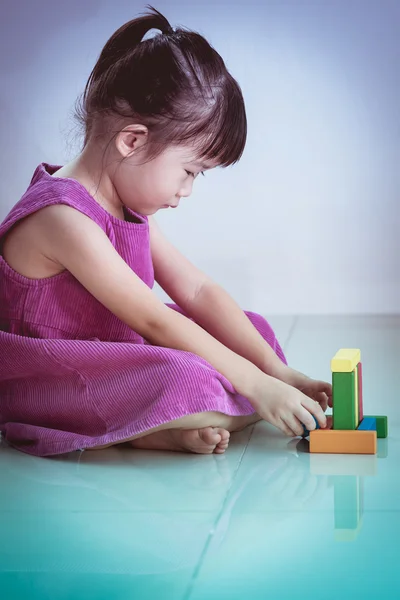 Precioso asiático chica jugando con bloques juguetes en el suelo . — Foto de Stock