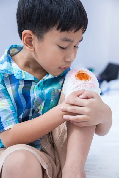 Niño herido. Herida en la rodilla del niño con vendaje . — Foto de Stock