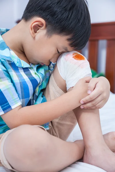 Enfant blessé. Blessure au genou de l'enfant avec bandage . — Photo