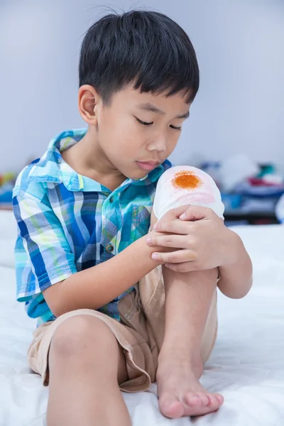 Child injured. Wound on the child's knee with bandage. — Stock Photo, Image