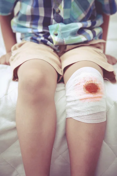 Niño herido. Herida en la rodilla del niño con vendaje. Efecto tono Vintage . — Foto de Stock