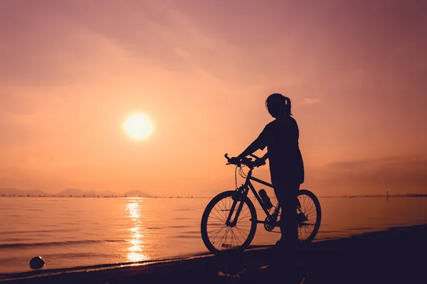 健康的骑自行车的人女孩享受着在海边景色的轮廓 — 图库照片