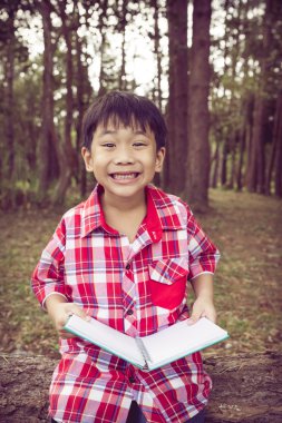 Asyalı çocuk gülümseyen ve bir kitap. Eğitim kavramı. Vintage tarzı.