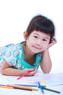 Çocuk yalan yere ve kağıt üzerine çizim üzerine. Beyaz arka plan üzerinde.