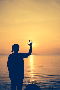 Siluet arkadan görünüm kadının relax deniz ve stop jest gösterilen.