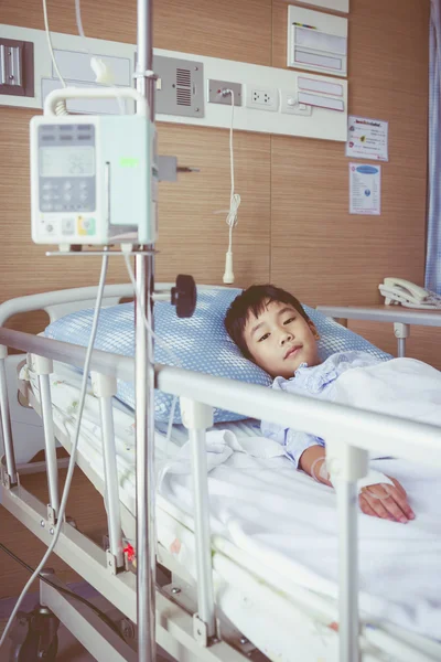 Asiatiska boy liggande på sjukbädd med infusion pumpen intravenöst DROPP. — Stockfoto