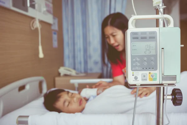 Niño asiático acostado en cama enferma con bomba de infusión intravenosa por goteo intravenoso. Estilo vintage . —  Fotos de Stock