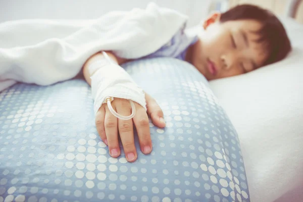 Niño asiático acostado en cama enferma con solución salina intravenosa (IV). Salud y concepto de personas. Estilo vintage . —  Fotos de Stock