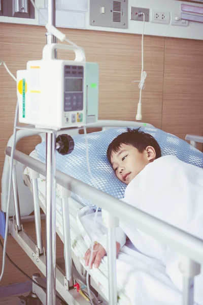 Asijské boy leží na lůžka s infúzní pumpy Iv intravenózně. — Stock fotografie