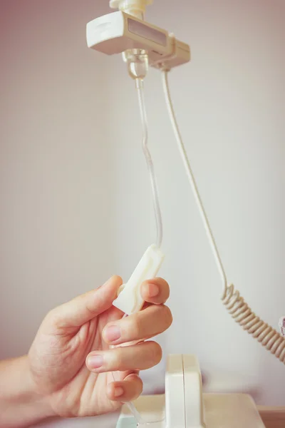 Nurse's hands regulation an intravenous (IV) drip in hospital room — Stock Photo, Image