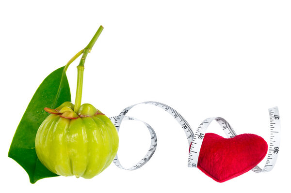 Garcinia cambogia fresh fruit with red heart and measuring tape