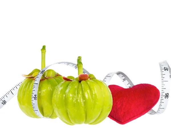 Garcinia cambogia fruta fresca com coração vermelho e fita métrica — Fotografia de Stock