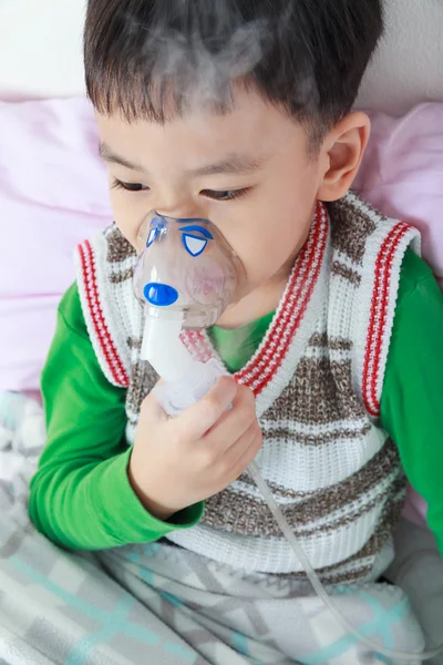 Niño asiático sostiene un inhalador de vapor máscara para el tratamiento del asma . —  Fotos de Stock