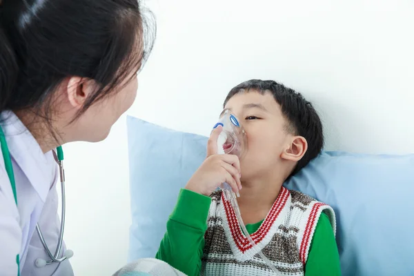 Asiático chico teniendo enfermedad respiratoria ayudado por el profesional de la salud con inhalador . —  Fotos de Stock