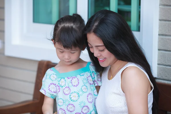 Aziatisch meisje met haar moeder in de buurt van door. Familie tijd doorbrengen samen thuis. — Stockfoto