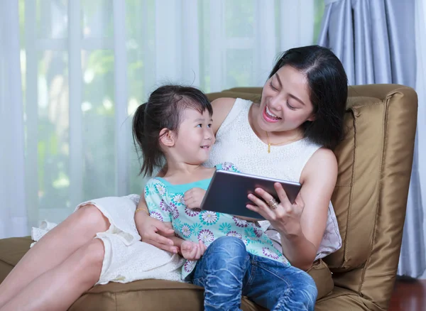 母亲和女儿使用数字平板电脑。花时间在一起在家里的家庭. — 图库照片