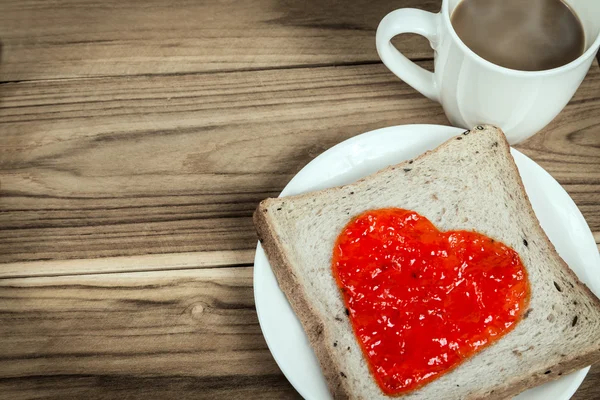 Délicieuse tranche de pain en forme de coeur de confiture de fraise — Photo