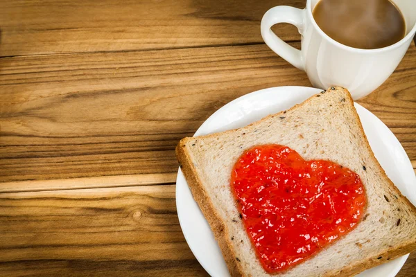 Délicieuse tranche de pain en forme de coeur de confiture de fraise — Photo