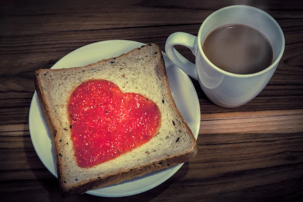 Deliciosa rebanada de pan con mermelada de fresa en forma de corazón — Foto de Stock