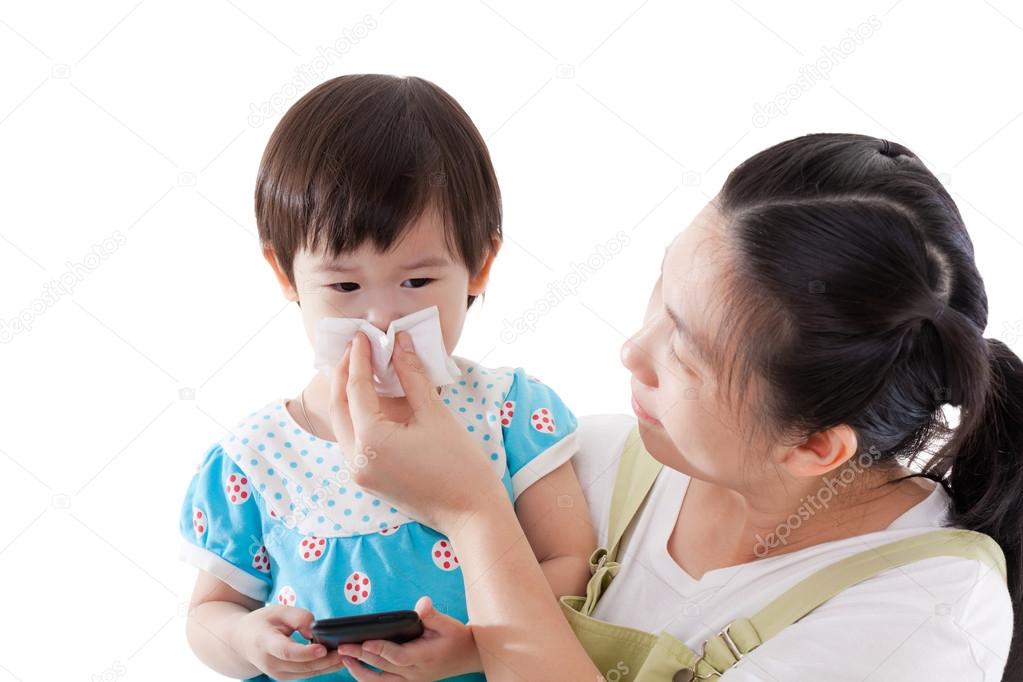 Asian mother carrying and blowing nose her daughter on white bac