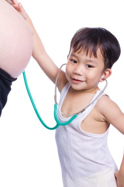 Little asian boy examining pregnant mother's tummy clipart