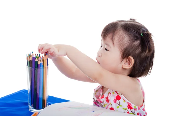 Mała dziewczynka siedzi i wybór kolorów ołówek, na białym tle — Zdjęcie stockowe