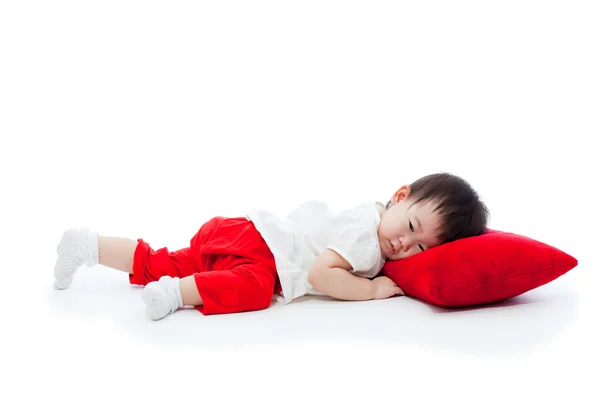Little girl lying on red pillow — Stock Photo, Image