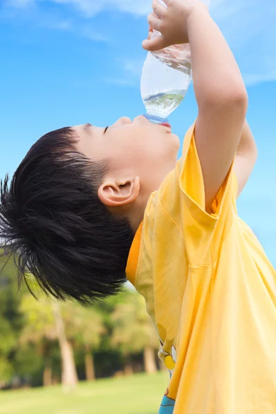 Little asian boy drinking water from plastic bottle Royalty Free Stock Photos