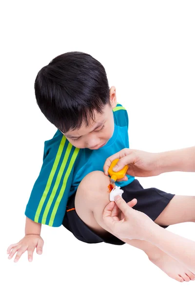 Liten asiatisk pojke tittar sår benet — Stockfoto