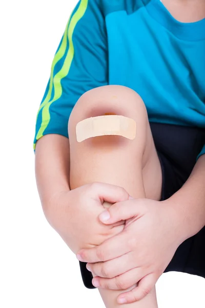 Детское колено со штукатуркой (для ран) и синяком — стоковое фото
