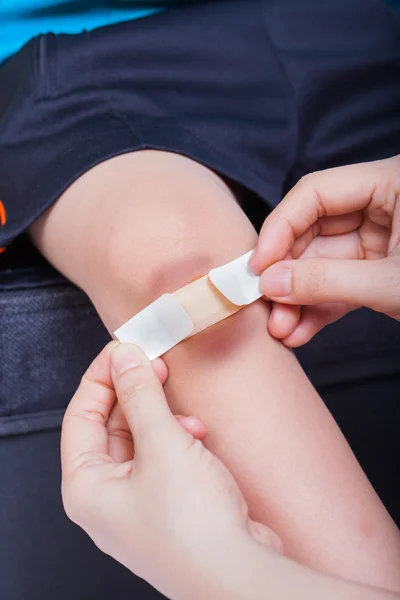Rodilla infantil con yeso (para heridas) y moretones —  Fotos de Stock
