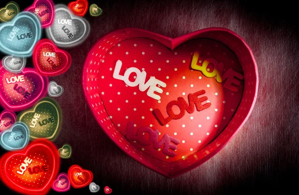 Hjärtformade presentförpackning och texten "Love" i rutan på mörk bakgrund — Stockfoto